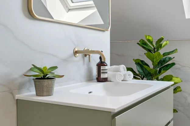 Cloakroom basin with brushed brass tap and marble-effect splashback