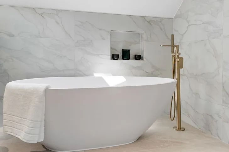 Freestanding bath with a brushed brass mixer tap